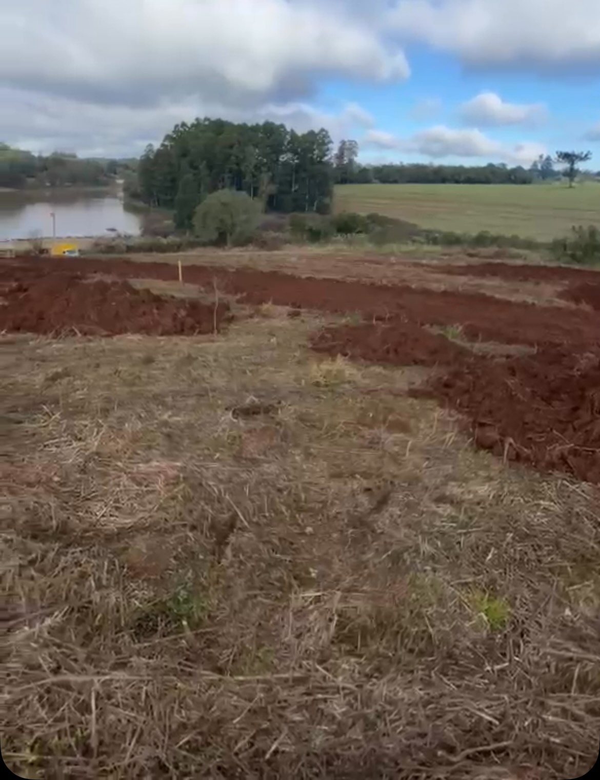 Terreno do condomínio já movimentado, com o lago ao fundo